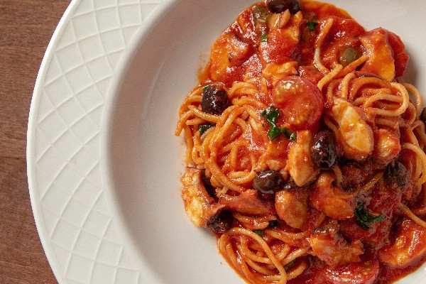 Гострі спагеті з восьминогом, свіжими томатами та каперсами